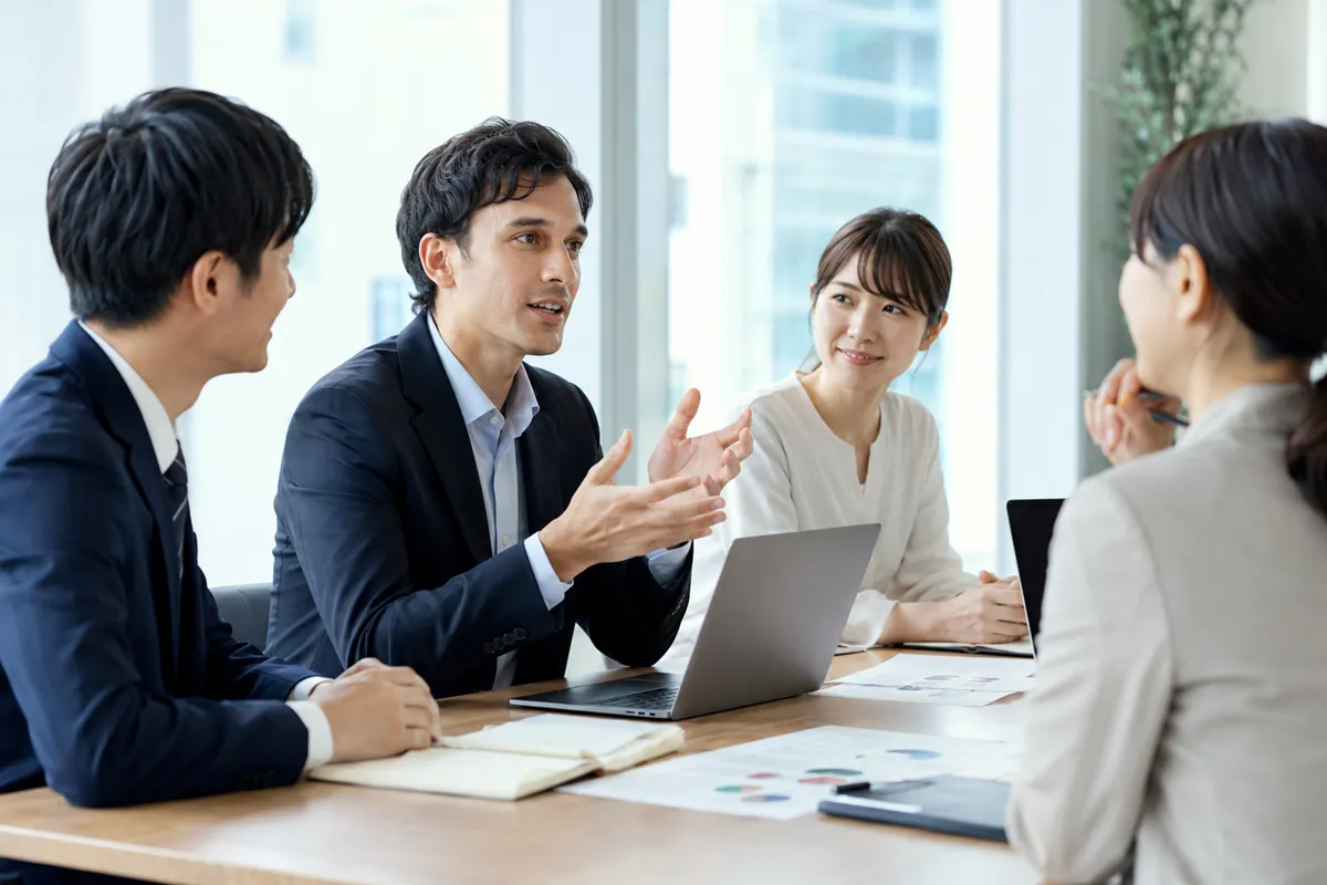 日本語で行われる社内会議で発言する外国人社員